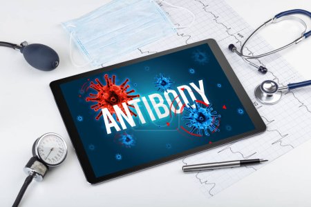 Photo pour Tablette pc et outils médicaux sur surface blanche avec inscription ANTIBODY, concept pandémique - image libre de droit