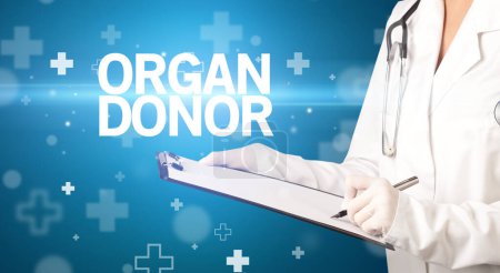 Photo for Doctor writes notes on the clipboard with ORGAN DONOR inscription, first aid concept - Royalty Free Image