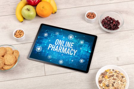 Foto de Concepto de farmacia en línea en la tableta PC con alimentos saludables alrededor, vista superior - Imagen libre de derechos