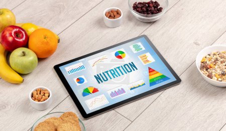 Photo for Organic food and tablet pc showing NUTRITION inscription, healthy nutrition composition - Royalty Free Image