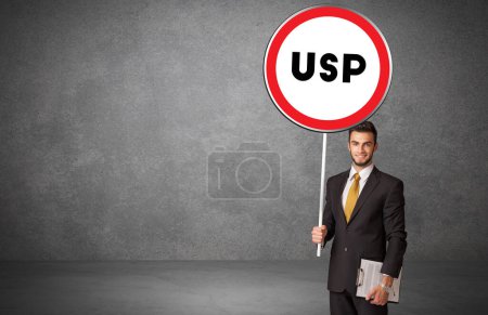 Téléchargez les photos : Jeune homme d'affaires holdig panneau de signalisation avec abréviation USP, concept de solution technologique - en image libre de droit