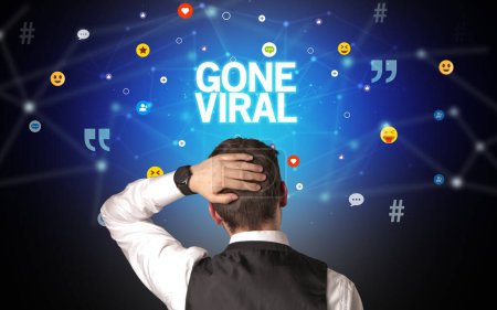 Foto de Vista trasera de un hombre de negocios con inscripción GONE VIRAL, concepto de redes sociales - Imagen libre de derechos