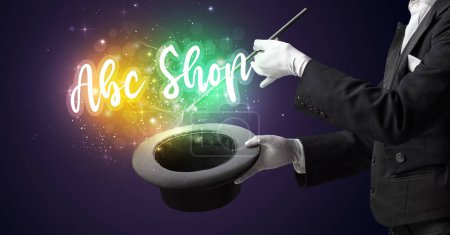 Téléchargez les photos : Magicien main conjure avec baguette et Abc Shop inscription, concept shopping - en image libre de droit