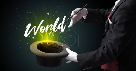 Photo for Magician is showing magic trick with World inscription, traveling concept - Royalty Free Image