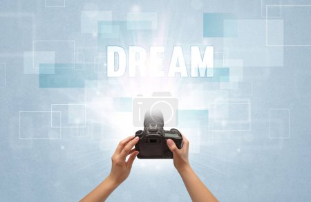 Téléchargez les photos : Gros plan d'un appareil photo numérique à main avec inscription DREAM, concept itinérant - en image libre de droit