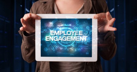 Photo for Young business person working on tablet and shows the inscription: EMPLOYEE ENGAGEMENT, business concept - Royalty Free Image