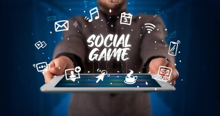 Photo for Young business person working on tablet and shows the inscription: SOCIAL GAME - Royalty Free Image
