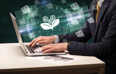 Photo for Business hand working in stock market with currency flower icons coming out from laptop screen - Royalty Free Image