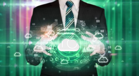 Téléchargez les photos : Homme d'affaires tenant icône nuage dans ses mains avec plusieurs symboles technologiques autour de lui - en image libre de droit