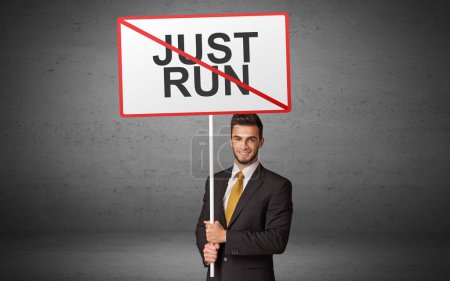 Photo for Business person holding a traffic sign with JUST RUN inscription, new idea concept - Royalty Free Image