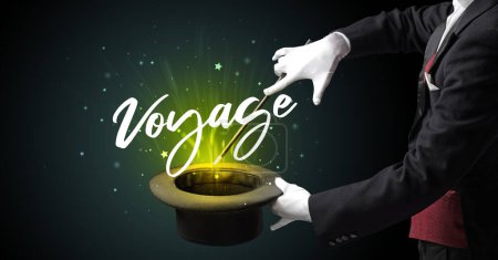 Foto de Mago está mostrando truco de magia con la inscripción Voyage, concepto de viaje - Imagen libre de derechos