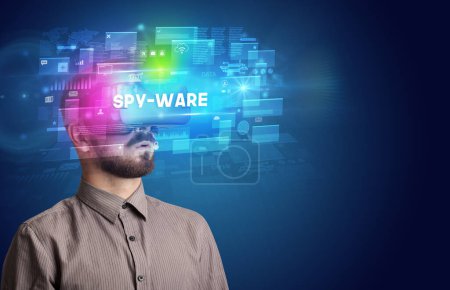Foto de Hombre de negocios mirando a través de gafas de realidad virtual con inscripción SPY-WARE, innovador concepto de seguridad - Imagen libre de derechos