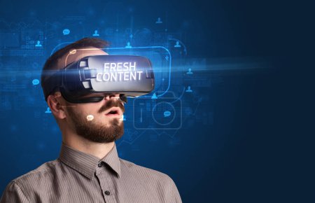 Téléchargez les photos : Homme d'affaires regardant à travers des lunettes de réalité virtuelle avec inscription FRESH CONTENT, concept de réseau social - en image libre de droit