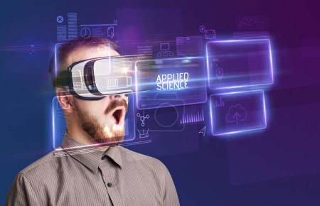 Téléchargez les photos : Homme d'affaires regardant à travers des lunettes de réalité virtuelle avec inscription SCIENCE APPLIQUÉE, concept de nouvelle technologie - en image libre de droit