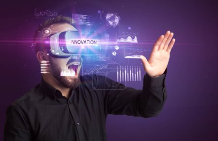 Foto de Hombre de negocios mirando a través de gafas de realidad virtual con inscripción INNOVATION, nuevo concepto de negocio - Imagen libre de derechos