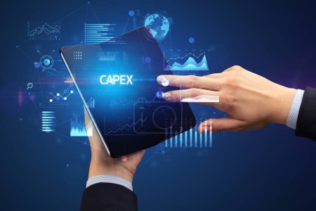 Empresario sosteniendo un teléfono inteligente plegable con inscripción CAPEX, concepto de negocio exitoso
