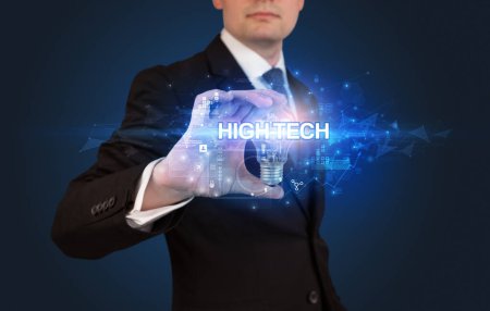 Foto de Empresario sosteniendo bombilla con inscripción HIGH-TECH, concepto de tecnología innovadora - Imagen libre de derechos