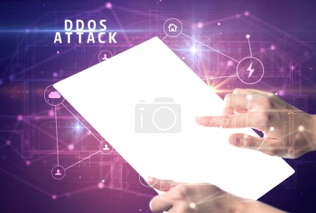 Téléchargez les photos : Tenir tablette futuriste avec inscription DDOS ATTACK, concept de cybersécurité - en image libre de droit