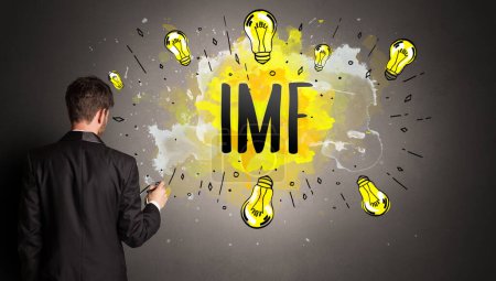 Téléchargez les photos : Homme d'affaires dessin ampoule colorée avec abréviation FMI, concept idée nouvelle technologie - en image libre de droit