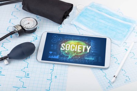 Foto de Tablet PC y herramientas médicas con inscripción SOCIEDAD, concepto de distanciamiento social - Imagen libre de derechos