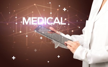 Photo for Doctor fills out medical record with MEDICAL inscription, medical concept - Royalty Free Image