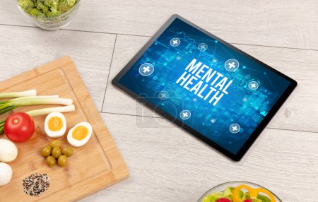 Foto de Concepto de salud mental en la PC tableta con alimentos saludables alrededor, vista superior - Imagen libre de derechos