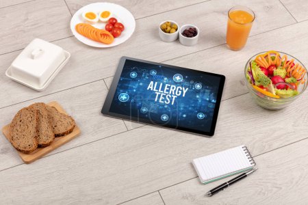 Foto de Concepto de prueba de alergia en la PC tableta con alimentos saludables alrededor, vista superior - Imagen libre de derechos