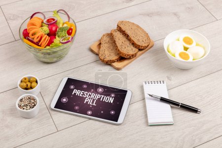 Téléchargez les photos : PRESCRIPTION PILL concept en comprimé PC avec des aliments sains autour, vue du dessus - en image libre de droit