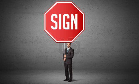 Téléchargez les photos : Jeune homme d'affaires tenant un panneau routier avec inscription SIGN, nouveau concept de règles - en image libre de droit