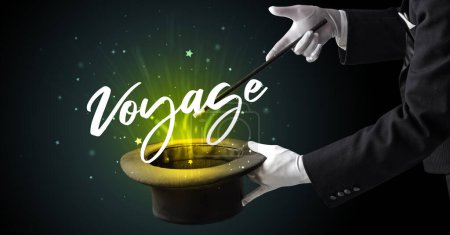Foto de Mago está mostrando truco de magia con la inscripción Voyage, concepto de viaje - Imagen libre de derechos