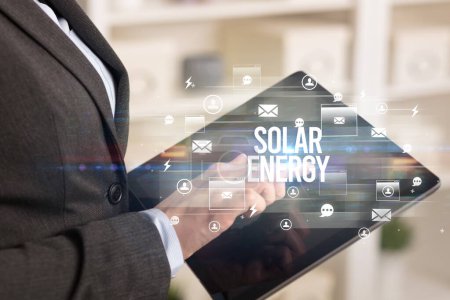 Téléchargez les photos : Gros plan d'une tablette cherchant l'inscription SOLAR ENERGY, concept de technologie moderne - en image libre de droit