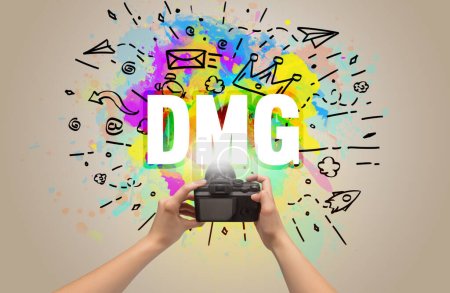 Téléchargez les photos : Gros plan d'un appareil photo numérique à main avec dessin abstrait et inscription DMG - en image libre de droit