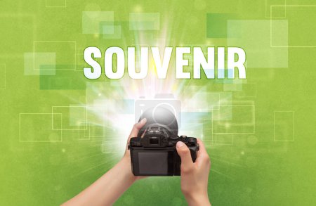 Téléchargez les photos : Gros plan d'un appareil photo numérique à main avec inscription SOUVENIR, concept itinérant - en image libre de droit