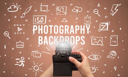 Photo for Hand taking picture with digital camera and PHOTOGRAPHY BACKDROPS inscription, camera settings concept - Royalty Free Image