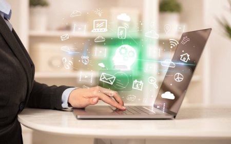 Foto de Empresario trabajando en el ordenador portátil con el hombre pensando iconos que salen de ella, concepto de negocio creciente - Imagen libre de derechos