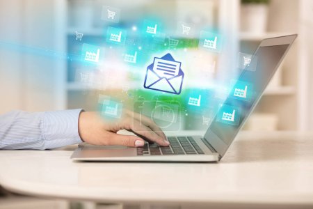 Téléchargez les photos : Homme d'affaires travaillant sur ordinateur portable avec des icônes de courrier qui en ressortent, concept d'entreprise réussi - en image libre de droit