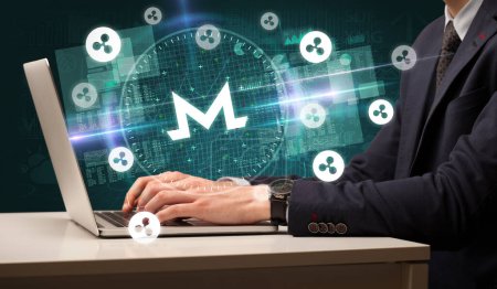 Photo for Business hand working in stock market with monero icons coming out from laptop screen - Royalty Free Image