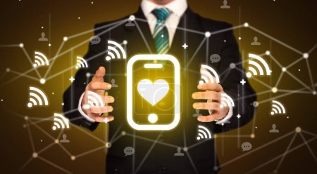 Photo for Hand holdig smartphone with heart icon around his hands, Social networking concept - Royalty Free Image