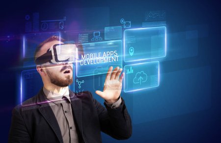 Photo for Businessman looking through Virtual Reality glasses with MOBILE APPS DEVELOPMENT inscription, new technology concept - Royalty Free Image