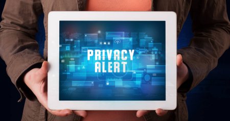 Photo for Young business person working on tablet and shows the digital sign: PRIVACY ALERT - Royalty Free Image
