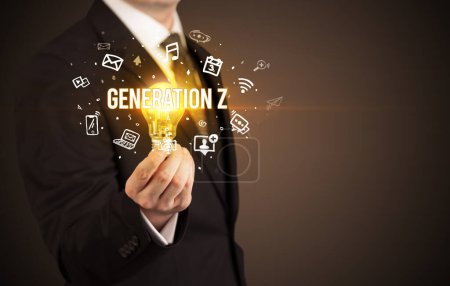 Photo for Businessman holding light bulb with GENERATION Z inscription, social media concept - Royalty Free Image