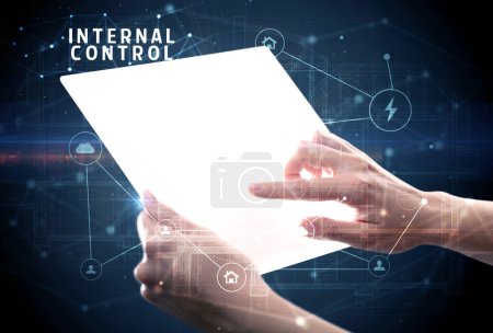 Téléchargez les photos : Tenir une tablette futuriste avec inscription INTERNAL CONTROL, concept de cybersécurité - en image libre de droit