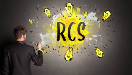 Photo for Businessman drawing colorful light bulb with RCS abbreviation, new technology idea concept - Royalty Free Image