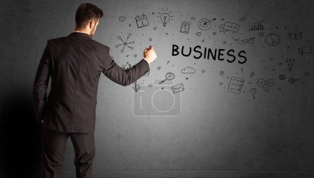 Téléchargez les photos : Homme d'affaires dessinant un croquis d'idée créative avec inscription BUSINESS, concept de stratégie d'entreprise - en image libre de droit