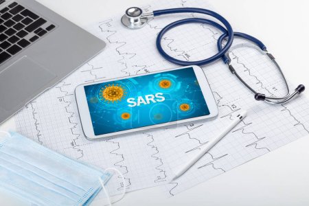 Foto de Vista de cerca de una tableta PC con inscripción SARS, concepto de microbiología - Imagen libre de derechos