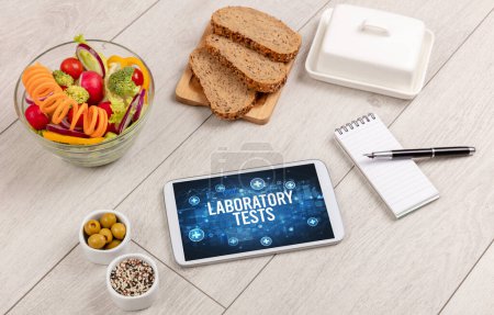 Foto de PRUEBAS DE LABORATORIO concepto en la tableta PC con alimentos saludables alrededor, vista superior - Imagen libre de derechos