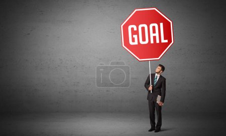 Photo for Young business person holding road sign with GOAL inscription, new rules concept - Royalty Free Image
