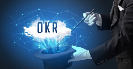 Foto de Mago está mostrando truco de magia con abreviatura OKR, concepto de tecnología moderna - Imagen libre de derechos
