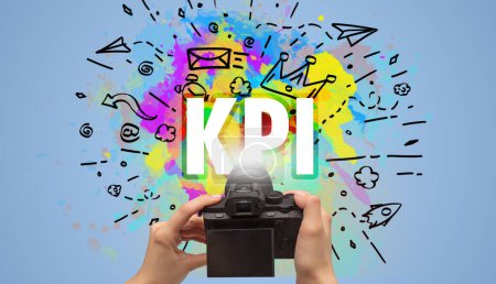 Téléchargez les photos : Gros plan d'un appareil photo numérique à main avec dessin abstrait et inscription KPI - en image libre de droit