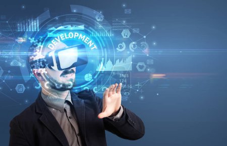 Foto de Hombre de negocios mirando a través de gafas de realidad virtual con inscripción DESARROLLO, concepto de tecnología innovadora - Imagen libre de derechos